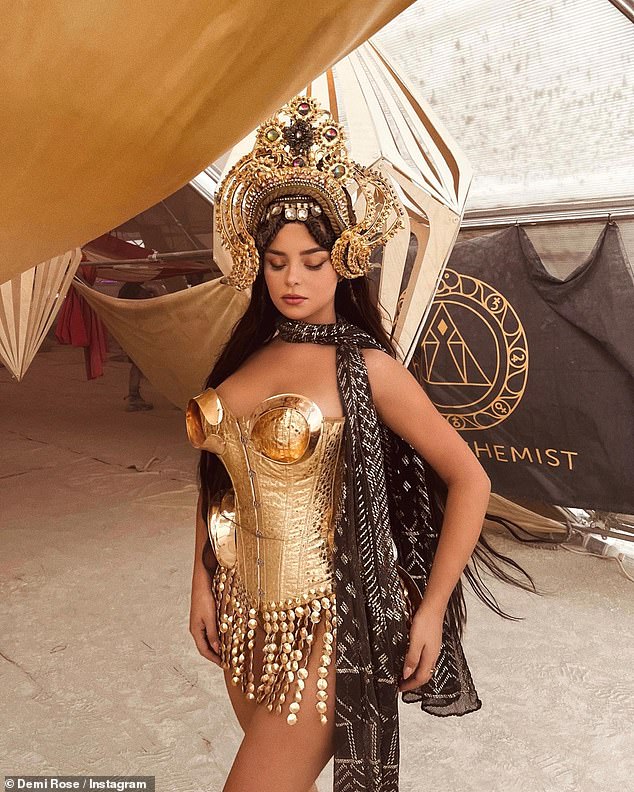 Demi Rose Dazzles in Gold Metal Corset and Dramatic Headpiece