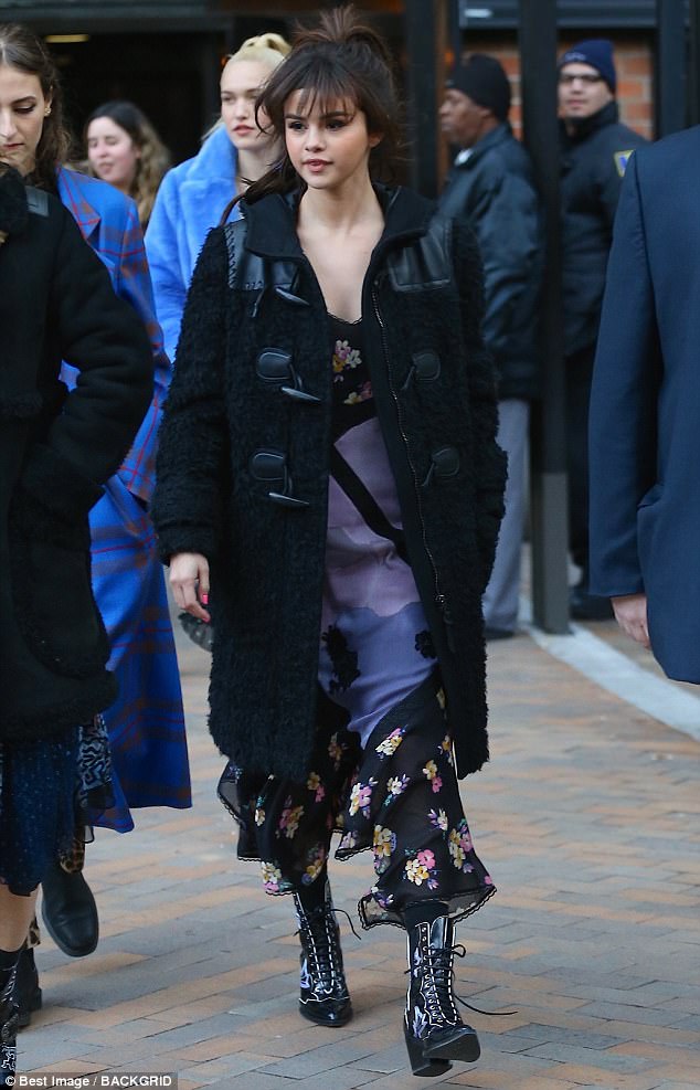 Stay warm! After taking in the fashion, Selena walked out of the show wearing a long, textured toggle coat